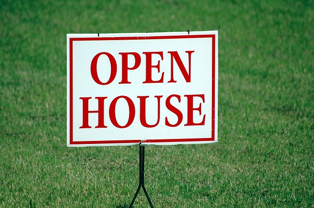 Open house sign with green grass in the background
