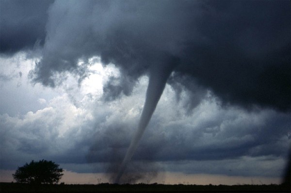 Photo of a tornado in the distance kicking up dust and debris